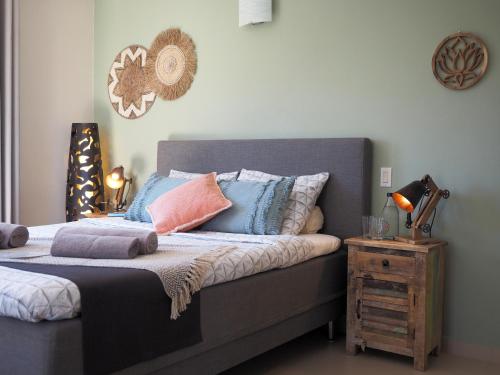 a bedroom with a bed with pillows and a night stand at Oasis guesthouse, Boutique Style Hotel in Kralendijk