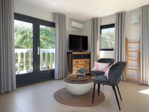 a living room with a tv and a chair at Oasis guesthouse, Boutique Style Hotel in Kralendijk