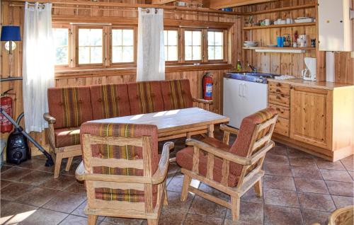 cocina con mesa de madera, sillas y encimera en Stallen 1, en Rauland