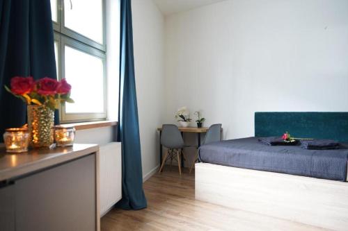a bedroom with a bed and a table and a window at Relax Jacuzzi Apartment in Krakow