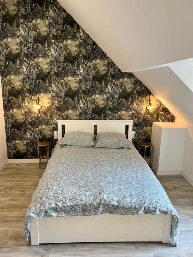 a bedroom with a large bed with a wall mural at Le Loft Jacuzzi in Ploërmel