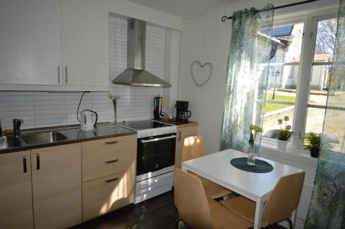 a kitchen with a sink and a table and a window at Högsnäsgården in Överhörnäs