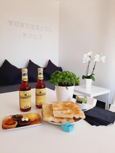 un tavolo con un piatto di pane e due bottiglie di birra di WONDERFUL NOLI - appartamento Noli Liguria Italia a Noli