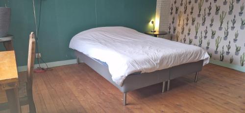 a small bed in a room with a wooden floor at Gastenkamers in vakantiewoning CasaCuriosa in Mol
