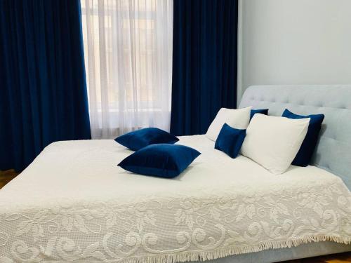 ein Bett mit blauen und weißen Kissen darauf in der Unterkunft Centr Opera House 2 rooms in Lwiw