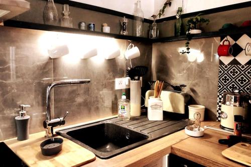 a kitchen with a sink and a counter top at NATIFRIENDLY-Appartement centre historique avec jardin IDEAL FAMILLE in Bellême