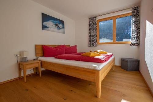 a bedroom with a bed with red pillows at Ferienwohnung Wallner in Wald am Arlberg