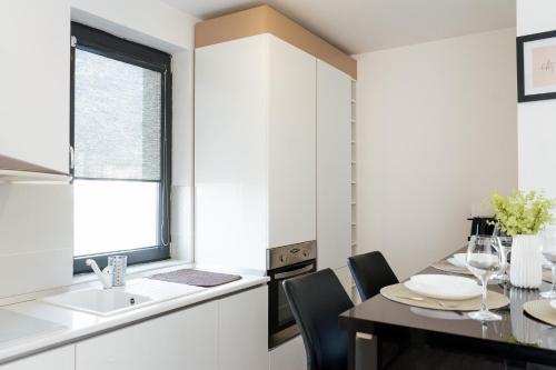 a kitchen with a table and chairs and a sink at Luxury Apartment with Private Parking in Giroc