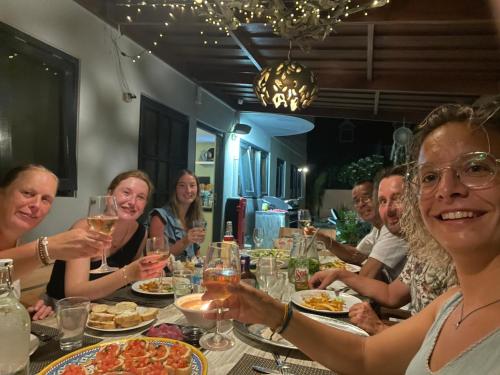 a group of people sitting at a table with wine glasses at Oasis guesthouse, Boutique Style Hotel in Kralendijk