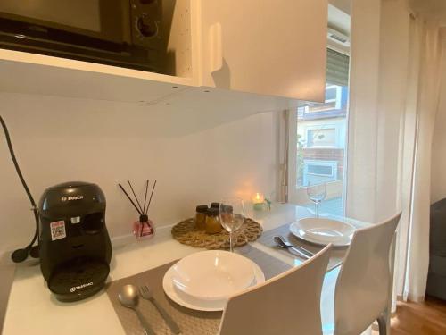 a kitchen with a table with white plates and a blender at Superbe Appartement cosy et calme avec un parking in Corbeil-Essonnes