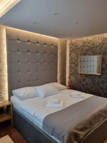 a bedroom with a large bed with a large headboard at Motel Bor in Vitez