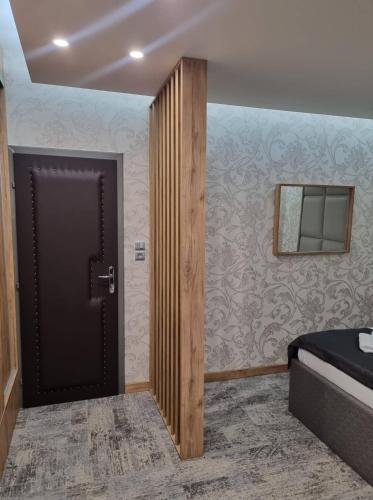 a bedroom with a door and a bed and a mirror at Motel Bor in Vitez