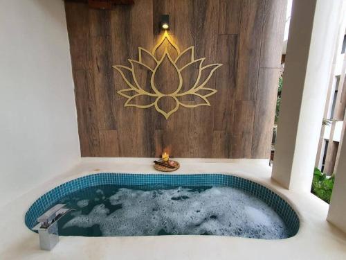 bañera con un cartel de loto en la pared en Smart Depas Elegante apartamento estudio totalmente equipado, en Tulum
