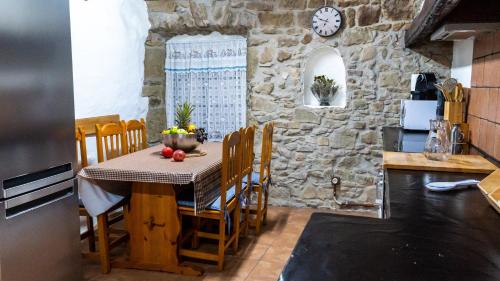 cocina con mesa y pared de piedra en Cal Belló Casa rural, en Lleida