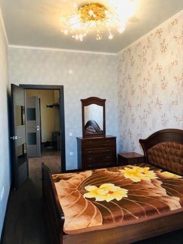 een slaapkamer met een groot bed met bloemen erop bij Квартира в центре Бишкека! in Bisjkek