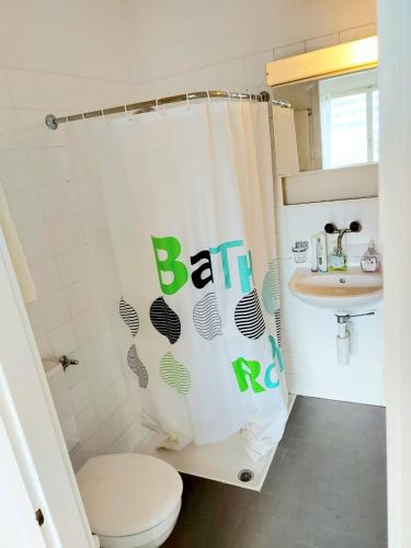 e bagno con tenda per la doccia, servizi igienici e lavandino. di Apartment Zentrum Bern Marzili a Berna