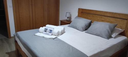 a bed with two pillows and a book on it at Casa do Meio in Alcofra