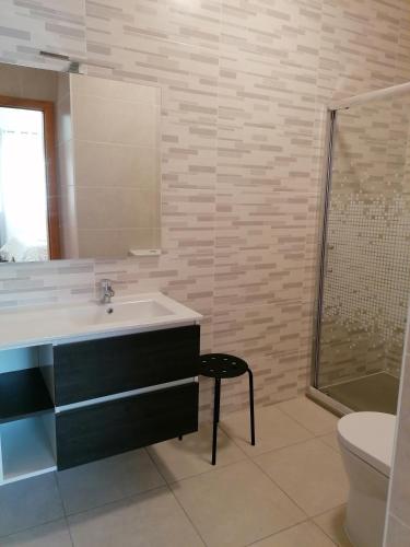 a bathroom with a sink and a shower and a toilet at Casa do Meio in Alcofra