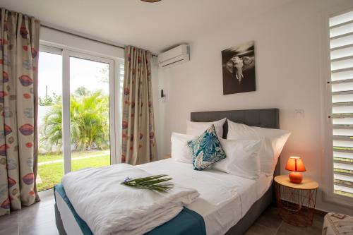 Postel nebo postele na pokoji v ubytování Hôtel Guadeloupe Palm Suites