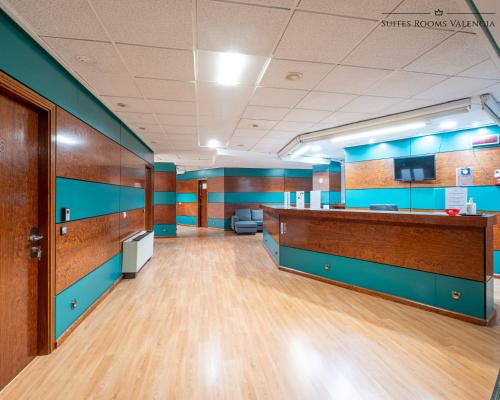 an office with a waiting room with blue walls and wooden floors at Suites Rooms Valencia in Valencia