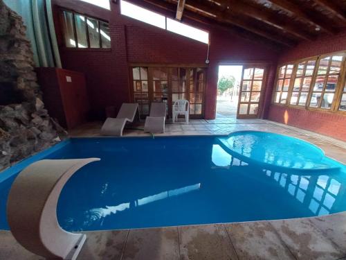 a large swimming pool in a building with blue water at Colorina Complejo Residencial in San Rafael