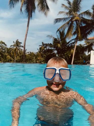 a young boy wearing goggles in a swimming pool at Villa Vanna in Unawatuna