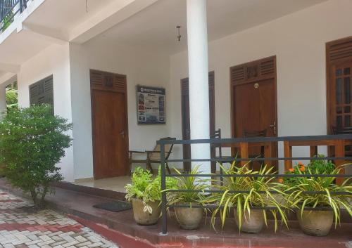 a building with potted plants sitting outside of it at Resident Villa in Unawatuna