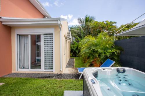 a jacuzzi tub in the backyard of a house at Hôtel Guadeloupe Palm Suites in Saint-François