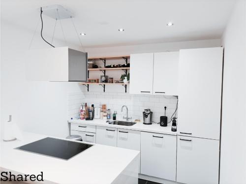 a white kitchen with white cabinets and a sink at Homestay Rotterdam in Rotterdam
