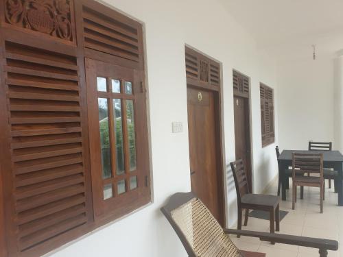 a room with wooden doors and a table and chairs at Resident Villa in Unawatuna