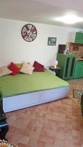 una camera da letto con un grande letto con un orologio sul muro di House dependance Belvedere a Misterbianco