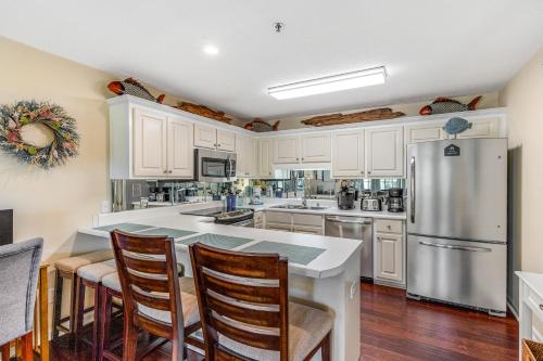 a kitchen with white cabinets and a stainless steel refrigerator at Boatin' n Fishin' in Panama City Beach