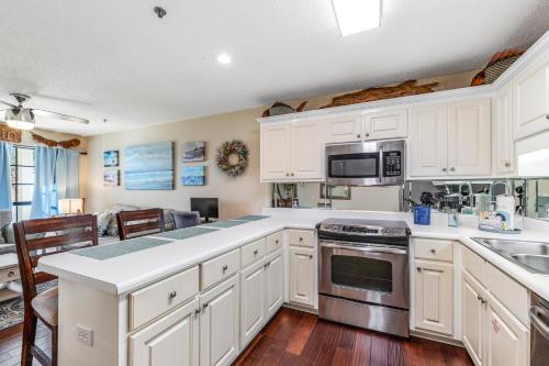 a kitchen with white cabinets and stainless steel appliances at Boatin' n Fishin' in Panama City Beach