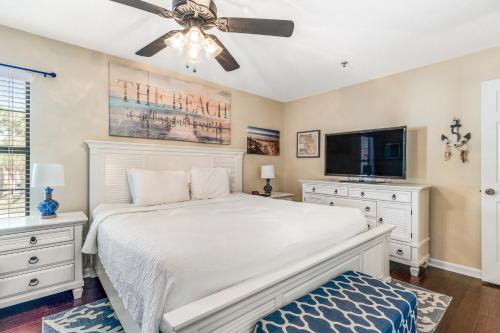 a bedroom with a white bed and a flat screen tv at Boatin' n Fishin' in Panama City Beach