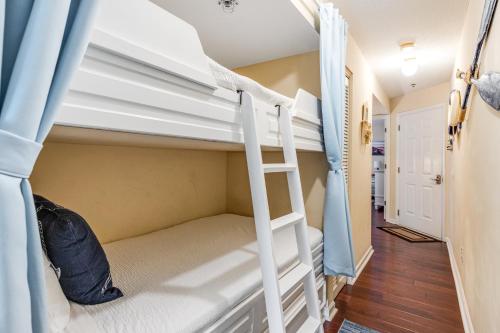a bunk bed in a dorm room with a ladder at Boatin' n Fishin' in Panama City Beach