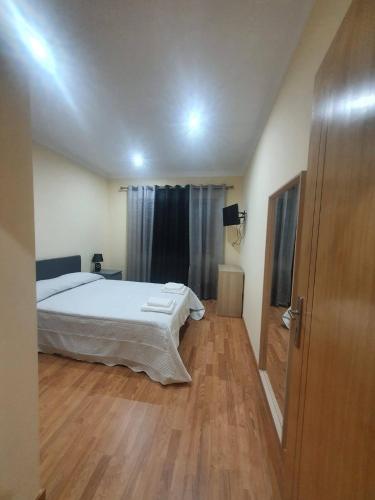 a bedroom with a bed and a wooden floor at Casa da Fonte em Prada, Vinhais in Vinhais