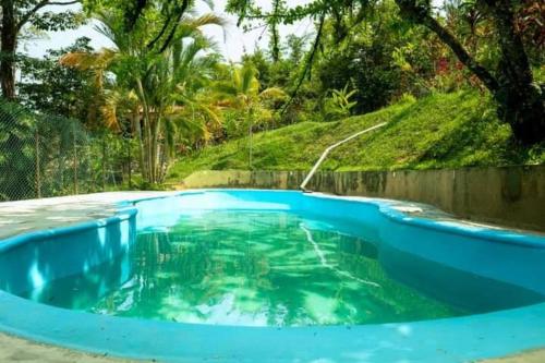 a blue swimming pool with a hill in the background at Finca Vista Hermosa - Deluxe Bamboo Cabana in Pluma Hidalgo