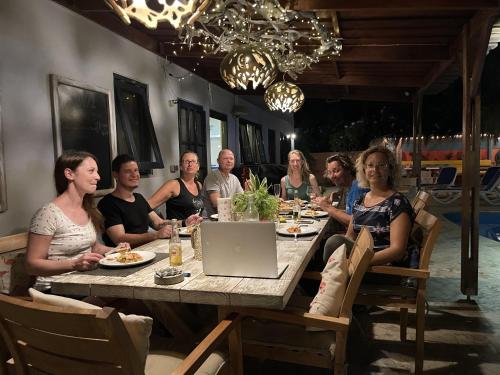 a group of people sitting at a table with a laptop at Oasis guesthouse, Boutique Style Hotel in Kralendijk