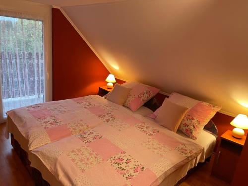 オロシュハーザにあるNapfény nyaralóのベッドルーム1室(ランプ2つ、窓付)