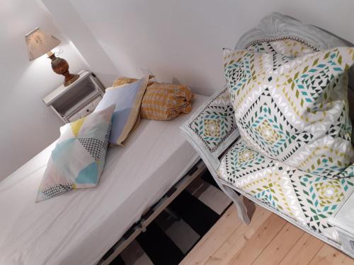 a bed with pillows and a table with a chair at studio lumineux dans la coulée verte à Saint gilles croix de vie in Saint-Gilles-Croix-de-Vie