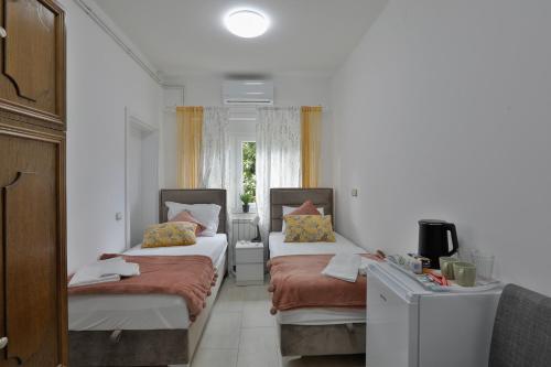 a room with two beds and a tv in it at AVIATOR Apartments & Rooms Nikola Tesla Airport Belgrade in Surčin