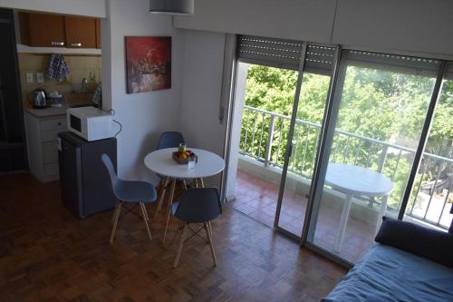 a living room with a table and chairs and a kitchen at Apartamento en Cordón Soho in Montevideo