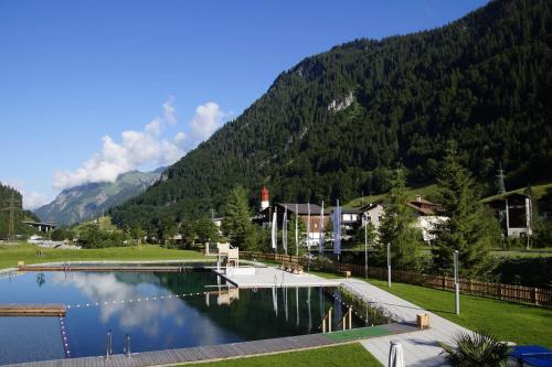 a swimming pool in front of a mountain at Haus Christopherus in Klösterle am Arlberg