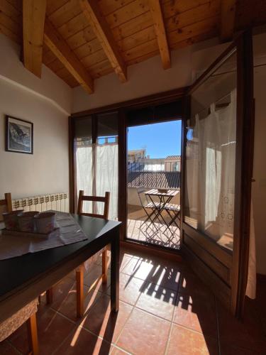 a dining room with a table and a view of a patio at Dúplex Teresa in Alcañiz