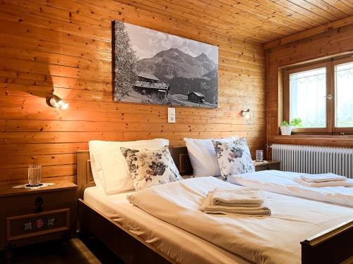sypialnia z łóżkiem w drewnianej ścianie w obiekcie Spitzen Blicke – Apartments w mieście Silbertal