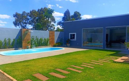 a house with a swimming pool and a yard at Recanto Felicitá in Foz do Iguaçu