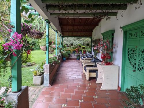 a patio with benches and flowers in a garden at Casa Finca Paititi in San Antonio de Pereira