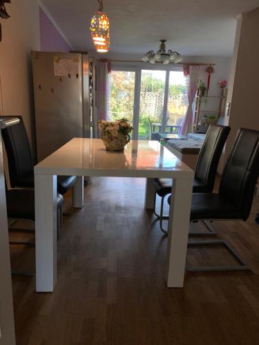 a white dining room table with black chairs around it at House Elinor Suite in Flörsheim am Main