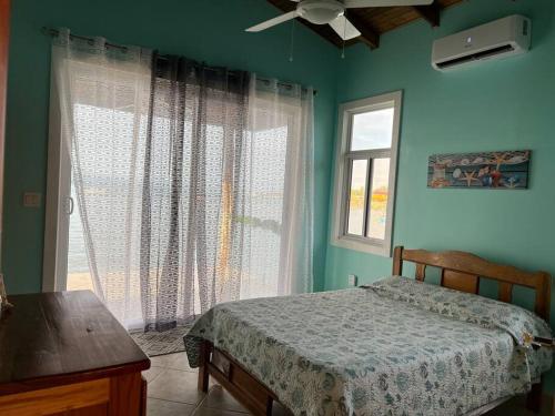 1 dormitorio con cama y ventana en Casita Azul, en Bastimentos