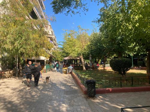 een stel dat een hond uitlaat in een park bij Sunny calm apartment in pedestrian street in Athene